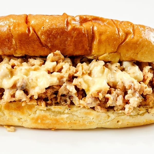 Cheesy chicken sandwich on a toasted bun, filled with chopped chicken and melted cheese.